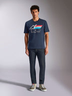 Alpinestars Trifecta CSF Tee, granatowa koszulka z krótkim rękawem, białe logo Astars z czerwonymi, białymi i jasnoniebieskimi pasami oraz napisem „Racing Ahead”, noszona z ciemnymi dżinsami i oliwkowymi sneakersami, codzienna odzież streetwearowa w stylu motorsportowym