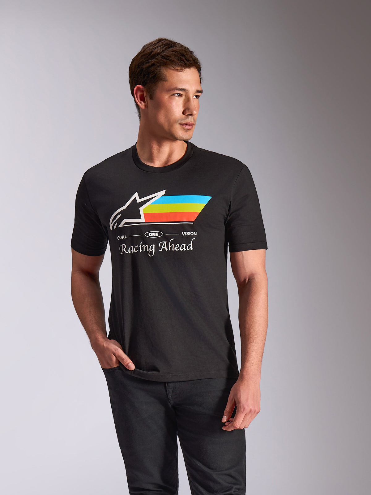 Alpinestars Trifecta CSF Tee, koszulka z krótkim rękawem, czarna, białe logo Astars z cyjanowymi, limonkowymi i pomarańczowymi poziomymi pasami, grafika z napisem „Racing Ahead”, codzienna odzież typu streetwear inspirowana motorsportem, prezentowana przez modela