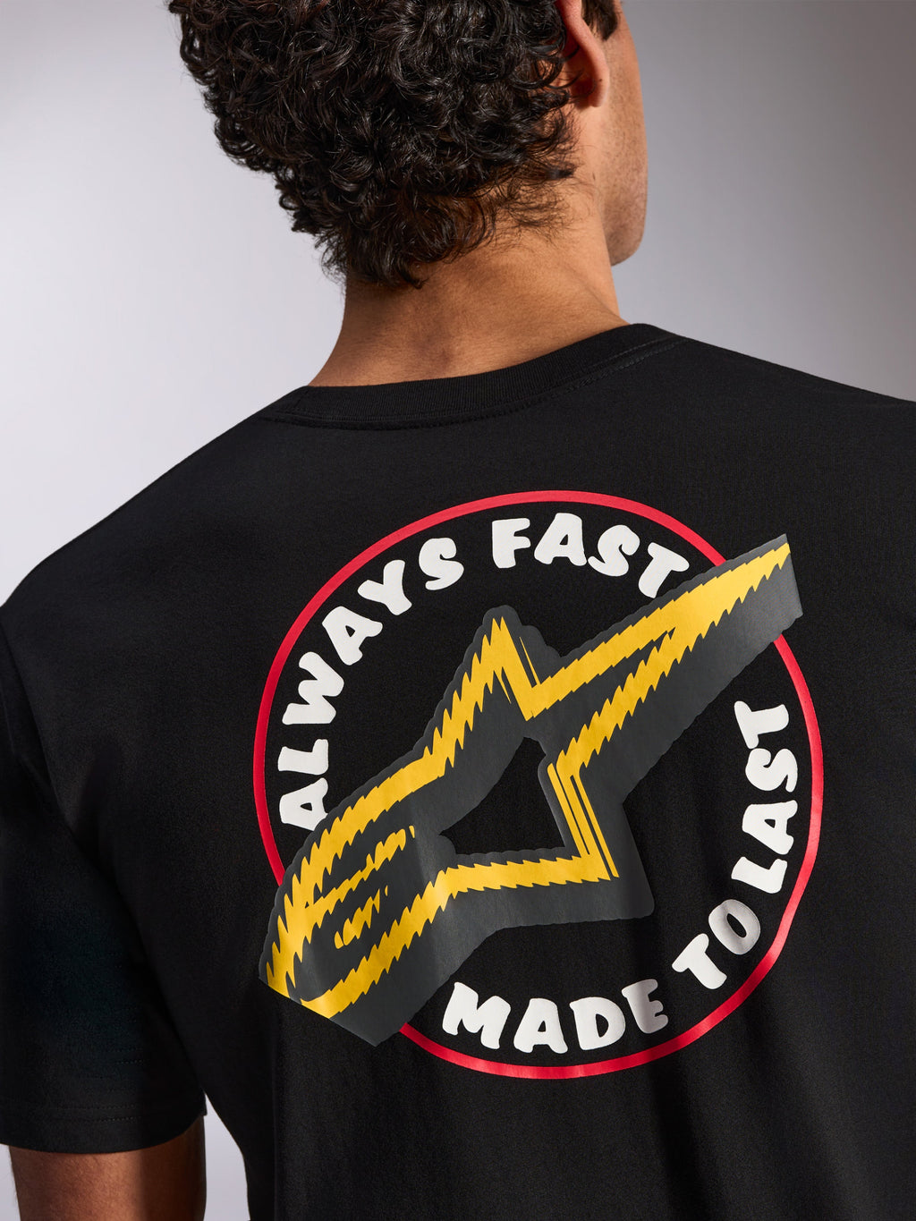 Alpinestars Aorbit CSF Tee, koszulka z krótkim rękawem, czarna, detale na plecach z grafiką Always Fast Made to Last i żółtym logo gwiazdy, codzienna odzież uliczna inspirowana sportami motorowymi
