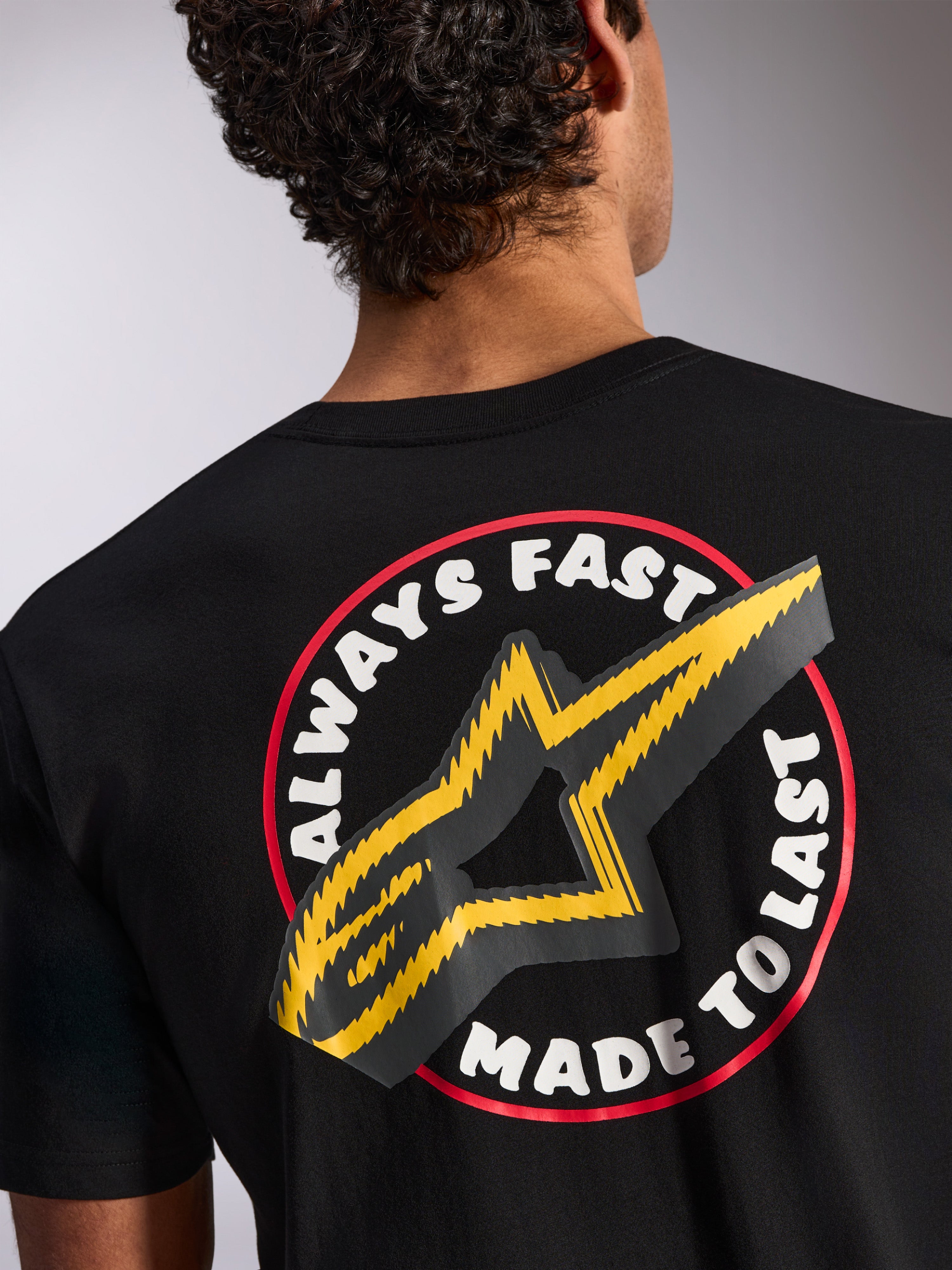 Alpinestars Aorbit CSF Tee, koszulka z krótkim rękawem, czarna, detale na plecach z grafiką Always Fast Made to Last i żółtym logo gwiazdy, codzienna odzież uliczna inspirowana sportami motorowymi