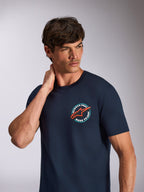 Alpinestars Aorbit CSF Tee, koszulka z krótkim rękawem, granatowa, okrągła grafika na klatce piersiowej z pomarańczowym logo gwiazdy i napisem „Always Fast Made to Last”, codzienna odzież streetwearowa w stylu motorsportowym