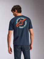 Alpinestars Aorbit CSF Tee, koszulka z krótkim rękawem, granatowa, widok z tyłu na modelu, okrągła grafika „Always Fast Made to Last” z czerwonym logo Astars, codzienna odzież streetwearowa inspirowana motorsportem