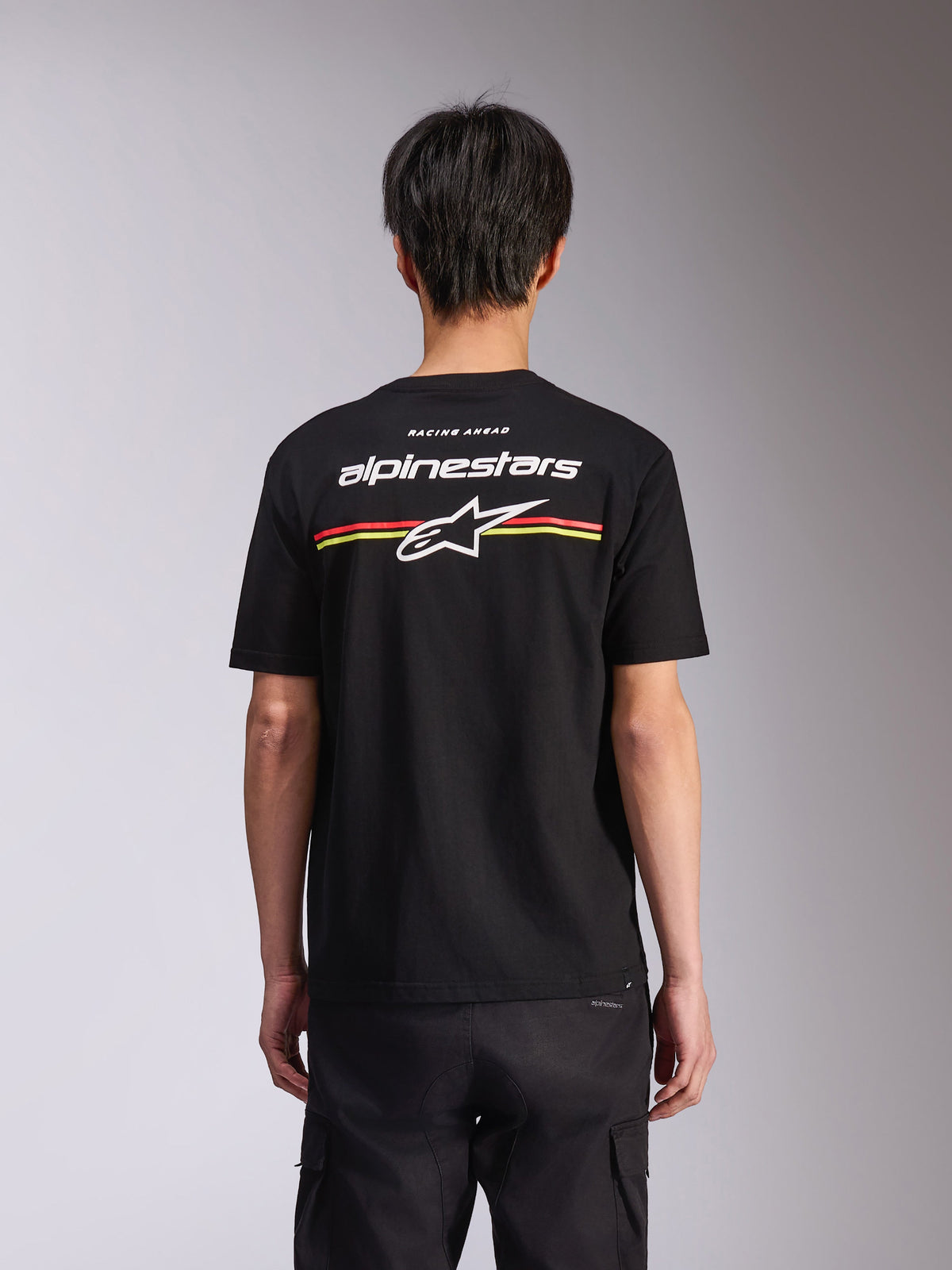 Alpinestars Lanes CSF Tee, czarna koszulka z krótkim rękawem, widok z tyłu z białym logo Alpinestars i gwiazdą Astars z czerwonymi i żółtymi paskami, casualowa odzież streetwear w stylu motorsport
