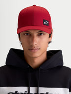 Alpinestars Czapka Pivot, ciemnoczerwona czapka z daszkiem sportswear, unisex, widok z przodu na modelu, haftowana naszywka z logo Astars, zakrzywiony daszek, usztywniona korona i trwała konstrukcja z kepru.