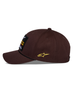 Czapka Alpinestars Matrix Snapback, brązowa, widok z boku, wygięty daszek z czarnym sznurkiem, haftowana naszywka z przodu, żółte logo Astars z boku, usztywniona konstrukcja z bawełnianego twillu, codzienna czapka w stylu motorsport