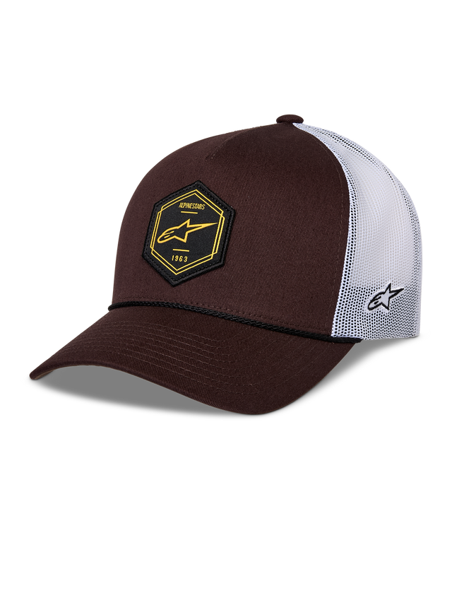 Alpinestars Hexeon Trucker Hat, brązowo-biała, zakrzywiony daszek z usztywnionym ciemnobrązowym przodem i białą siateczką z tyłu, czarna sześciokątna naszywka z żółtym logo z przodu, haftowane logo z boku, klasyczny fason typu trucker.
