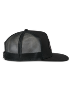 Alpinestars Contender Trucker Hat, czarna czapka typu trucker, widok z boku, płaski daszek i oddychające panele z siateczki z tyłu, zapięcie snapback, casualowy styl motorsportowy