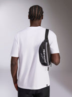 Alpinestars Only Linear Hip Bag, czarna nerka z białym logo Alpinestars, noszona jako torba crossbody na białym t-shircie, codzienny dodatek streetwearowy inspirowany sportami motorowymi