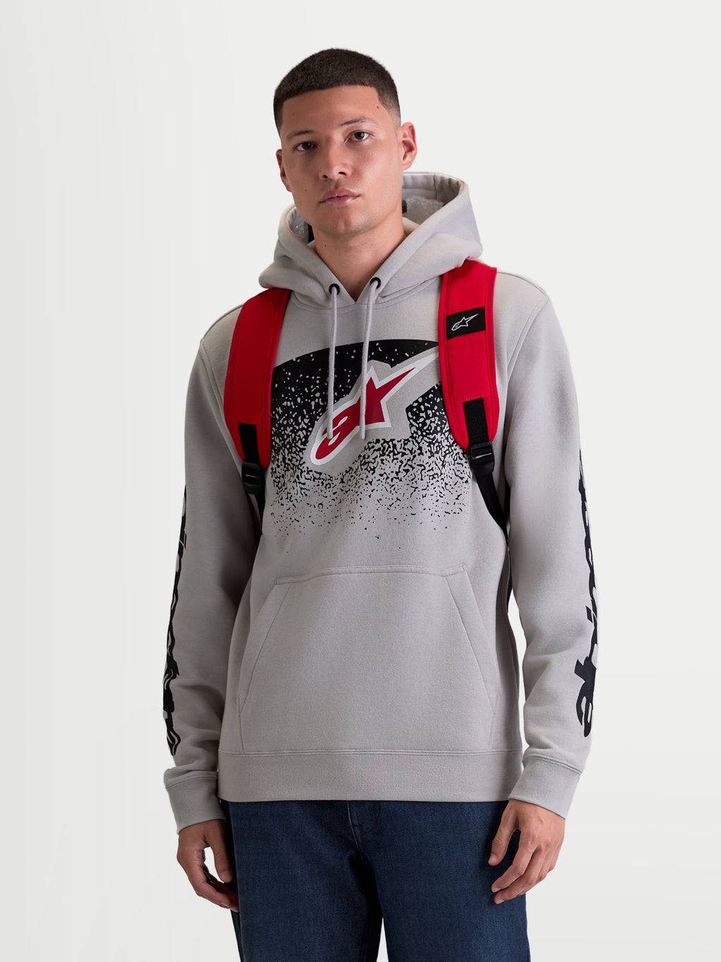 Alpinestars Plecak GFX Boss, sportowy plecak miejski o pojemności 20 l, męski i damski, czerwony i czarny, wykonany z wytrzymałego poliestru 600D, widok z przodu na modelu, regulowane ramiączka z siatki i wypukłe silikonowe logo.