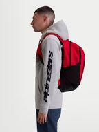 Alpinestars plecak GFX Boss, miejski plecak sportowy o pojemności 20l, czerwony i czarny, wykonany z wytrzymałego poliestru 600D, boczne siatkowe kieszenie na butelkę i wyściełane ramiączka, widoczny na modelu, idealny do codziennego użytku i miejskich dojazdów.