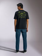 Alpinestars Order CSF Tee, koszulka z krótkim rękawem, czarna, widok z tyłu z oliwkową grafiką kasku i palm oraz napisem „One Goal One Vision”, codzienna odzież streetwearowa w stylu motorsportowym