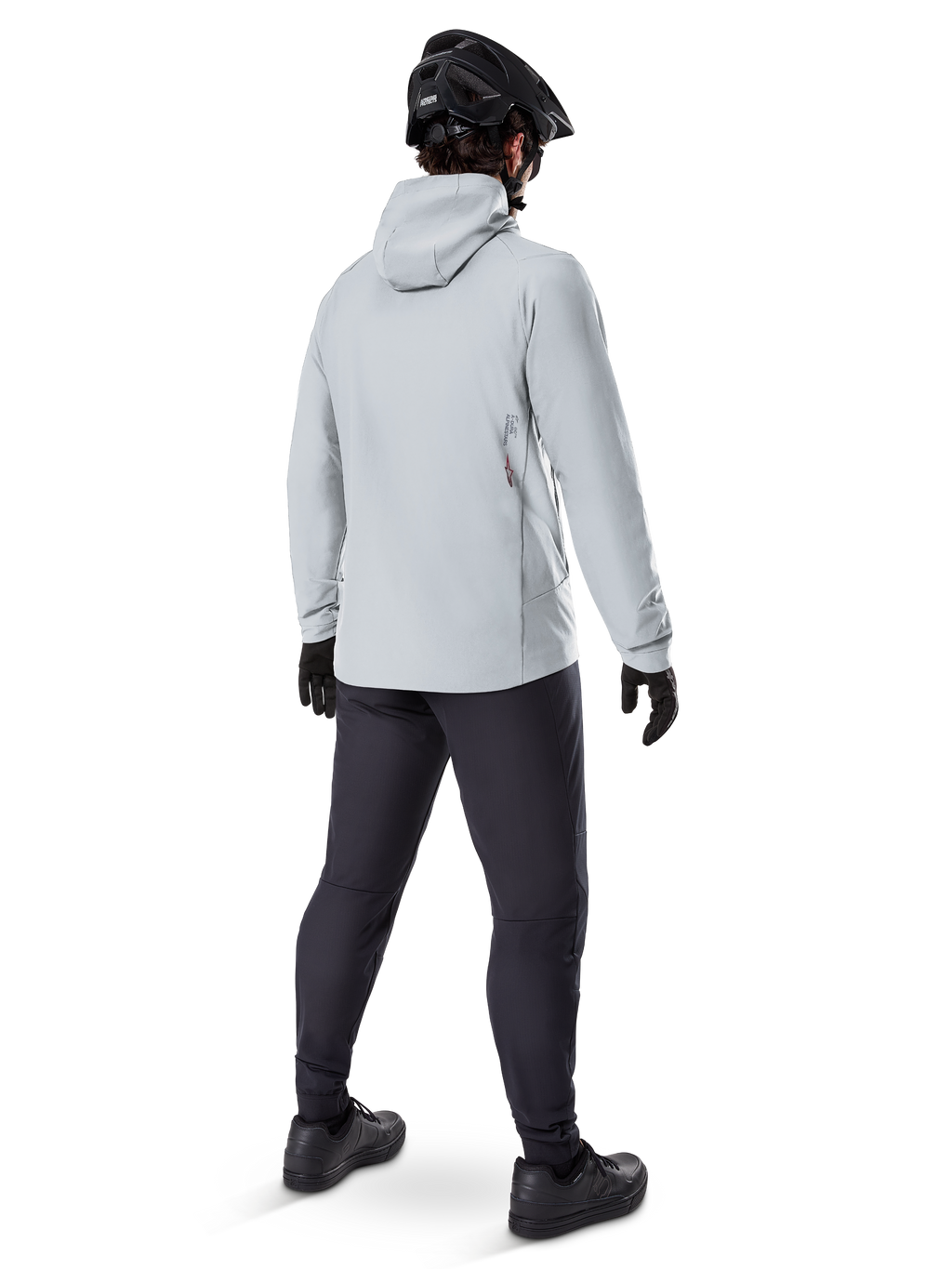 Alpinestars A-Dura Thermal Jacket w kolorze Titanium, widok od tyłu na rowerzystę ubranego w jasnoszarą kurtkę termiczną z kapturem, czarny kask MTB, czarne rękawiczki i ciemnoszare spodnie, funkcjonalna odzież do jazdy na rowerze górskim