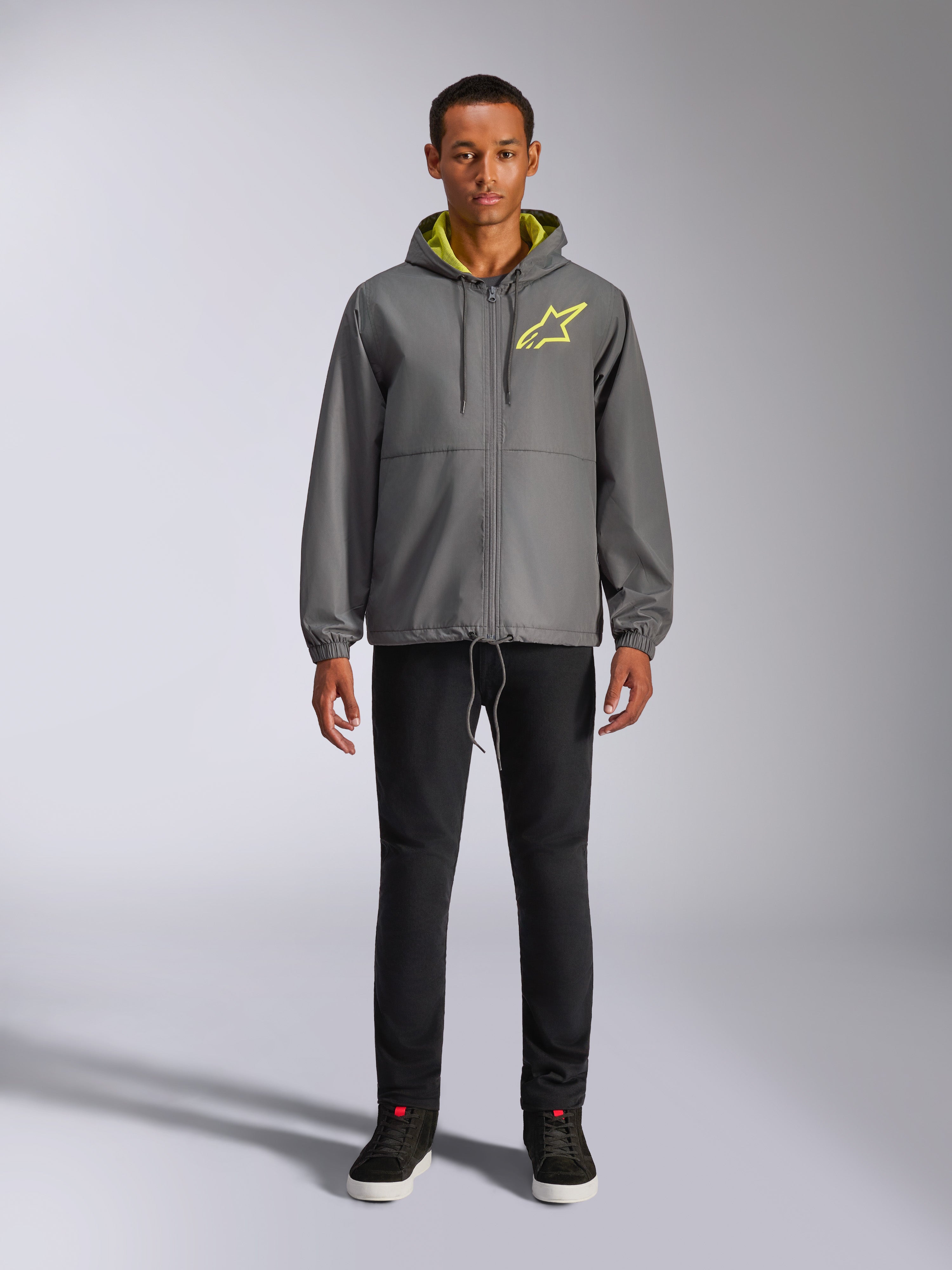 Alpinestars Speeder Chromium Windbreak Jacket, Charcoal gray hooded jacket with high-vis yellow lining and chest logo, full-zip front, elastic cuffs, casual motorsport-inspired streetwear