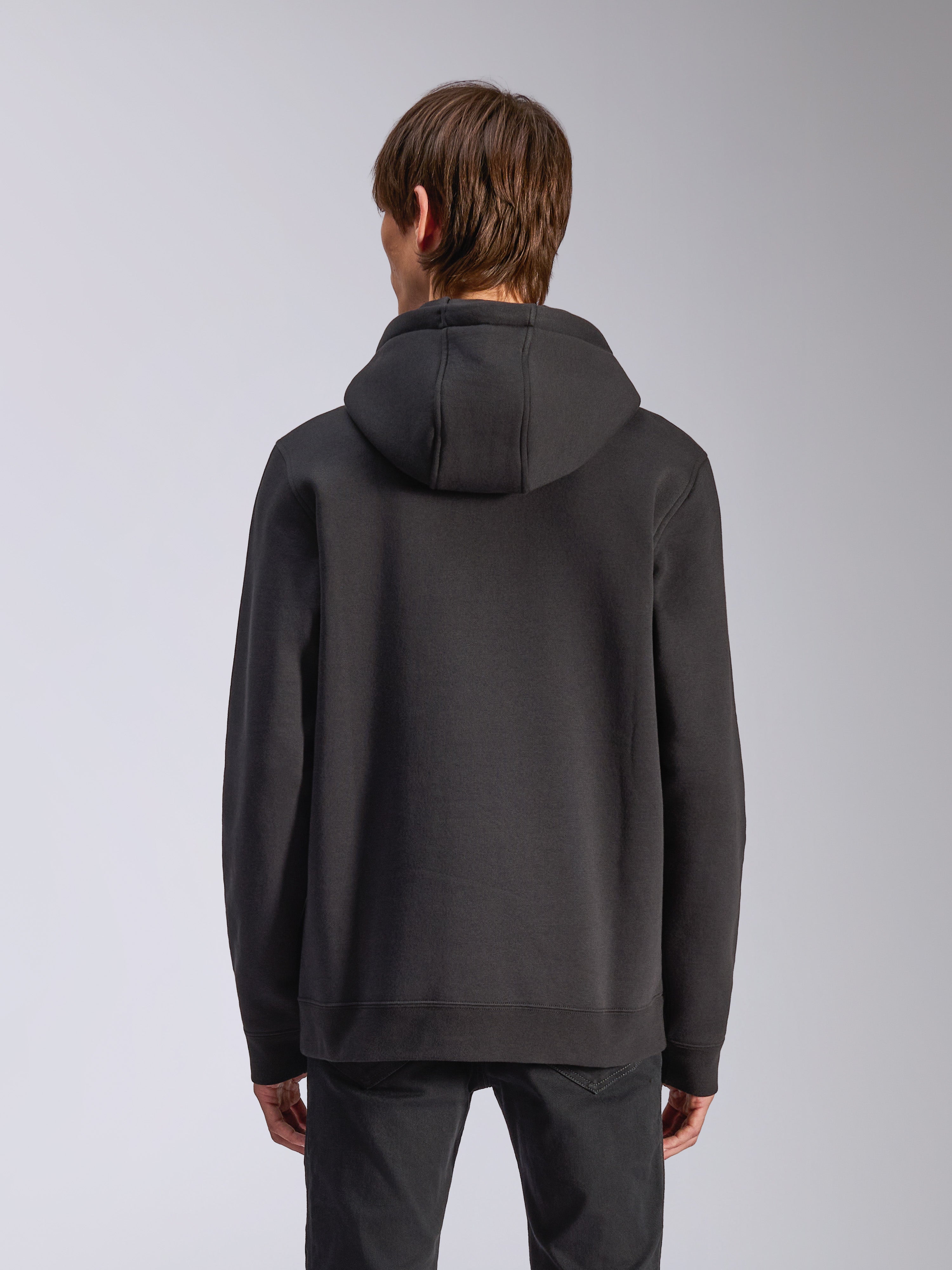 Alpinestars Harken Hoodie, czarna, widok z tyłu na męskiego modela ubranego w codzienną polarową bluzę, ściągacze przy mankietach i dole, nowoczesna odzież uliczna inspirowana sportami motorowymi