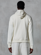 Alpinestars Essentials Ageless Hoodie, kremowa bluza z kapturem typu pullover, widok z tyłu na modelu, czysty minimalistyczny design, pasujące spodnie codzienne, luźny krój zapewniający codzienny komfort