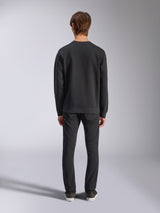 Alpinestars Bettern Crew, czarna bluza typu crewneck, widok z tyłu na modelu, ściągacz przy kołnierzu i na dole, codzienna odzież uliczna inspirowana sportami motorowymi