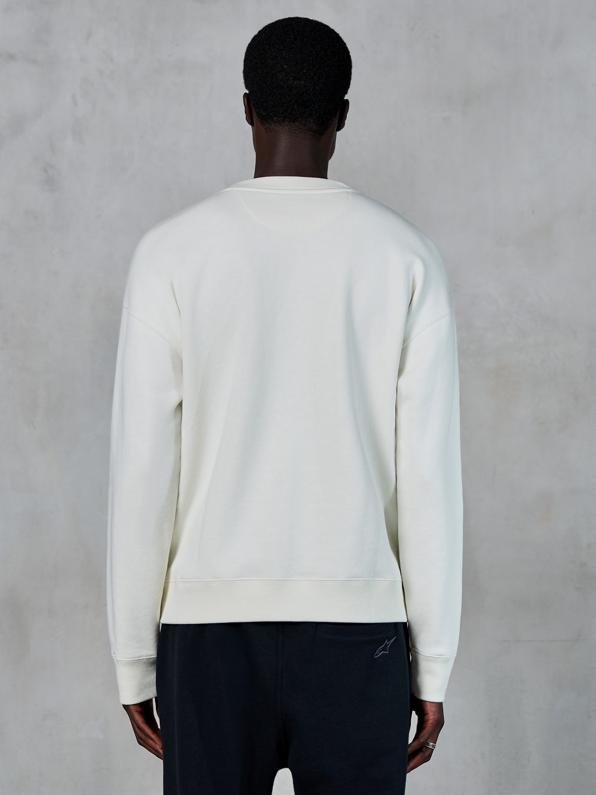 Alpinestars Essentials Ageless Crew, bluza typu crewneck w kolorze złamanej bieli, widok z tyłu, codzienna odzież sportowa, ściągacze na mankietach i u dołu, minimalistyczny design o swobodnym kroju, wysokiej jakości miękki materiał polarowy