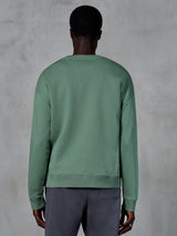 Alpinestars Essentials Ageless Crew, bluza z okrągłym dekoltem, zielona (Cactus), widok z tyłu na modelu, ściągacze przy mankietach i na dole, wysokiej jakości kompaktowy polar, codzienny styl streetwear