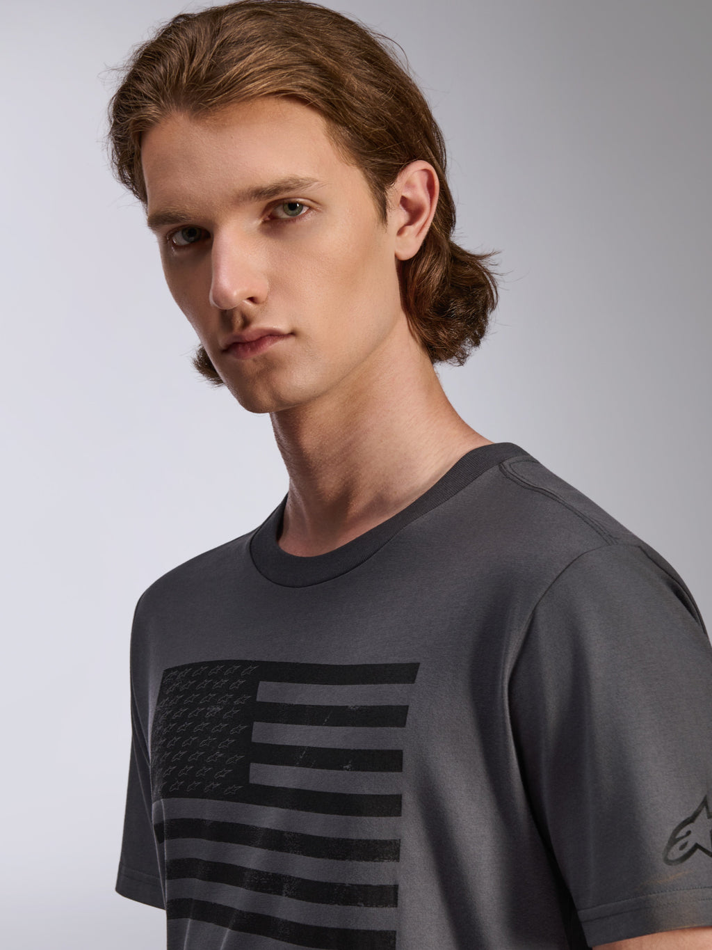Alpinestars Waving CSF Tee, koszulka z krótkim rękawem, grafitowa, z czarną grafiką flagi z efektem postarzenia i małymi gwiazdkami, męska odzież sportowa