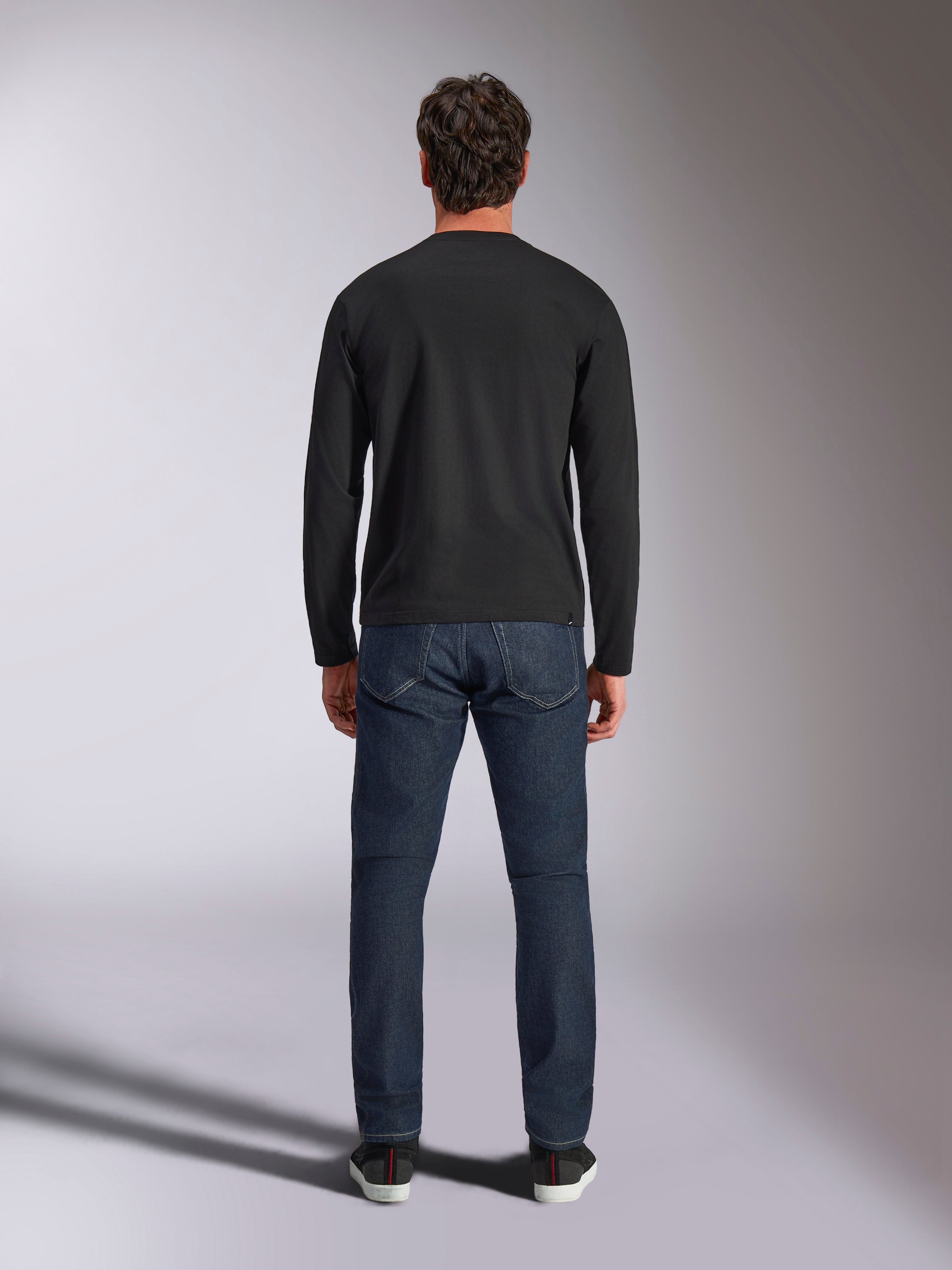 Alpinestars Trackside CSF Tee, koszulka z długim rękawem, czarna, widok z tyłu na modelu w ciemnoniebieskich jeansach, casualowa odzież streetwearowa w stylu motorsportowym
