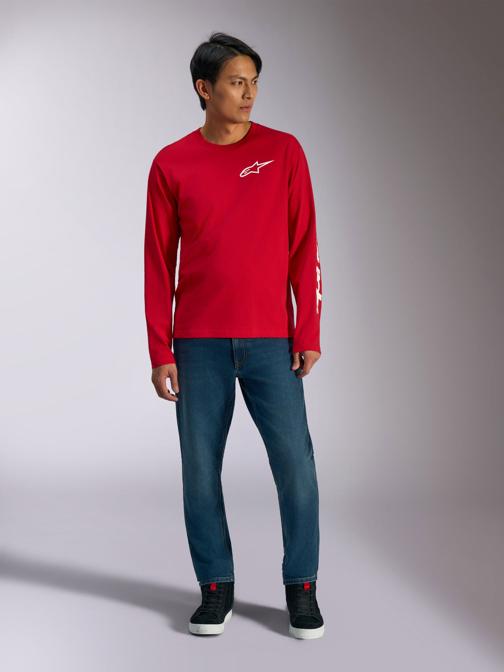 Alpinestars Trackside CSF Tee, Long Sleeve T-Shirt, Red with White Alpinestars Logo, lifestyle shot worn with blue jeans and black sneakers, casual motorsport-inspired sportswear