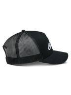 Alpinestars Ageless Trucker Hat, czarna czapka z daszkiem, widok z boku prezentujący usztywnioną koronę i białe haftowane logo Astars, zakrzywiony daszek oraz oddychające czarne panele z siatki poliestrowej.