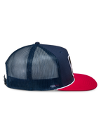 Alpinestars Control Trucker Hat, granatowo-czerwona czapka typu trucker, widok z profilu pokazujący granatowy przód z twillu i panele z siatki, płaski czerwony daszek z białą plecioną linką, codzienne nakrycie głowy inspirowane motorsportem