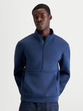 Alpinestars bluza Apera Half-Zip prezentowana na modelu, męska bluza sportowa z zamkiem do połowy i kieszenią kangurką, kolor stalowy niebieski, tonalne logo Alpinestars, wykonana z dwustronnego polaru tri-blend, styl casualowy inspirowany motorsportem