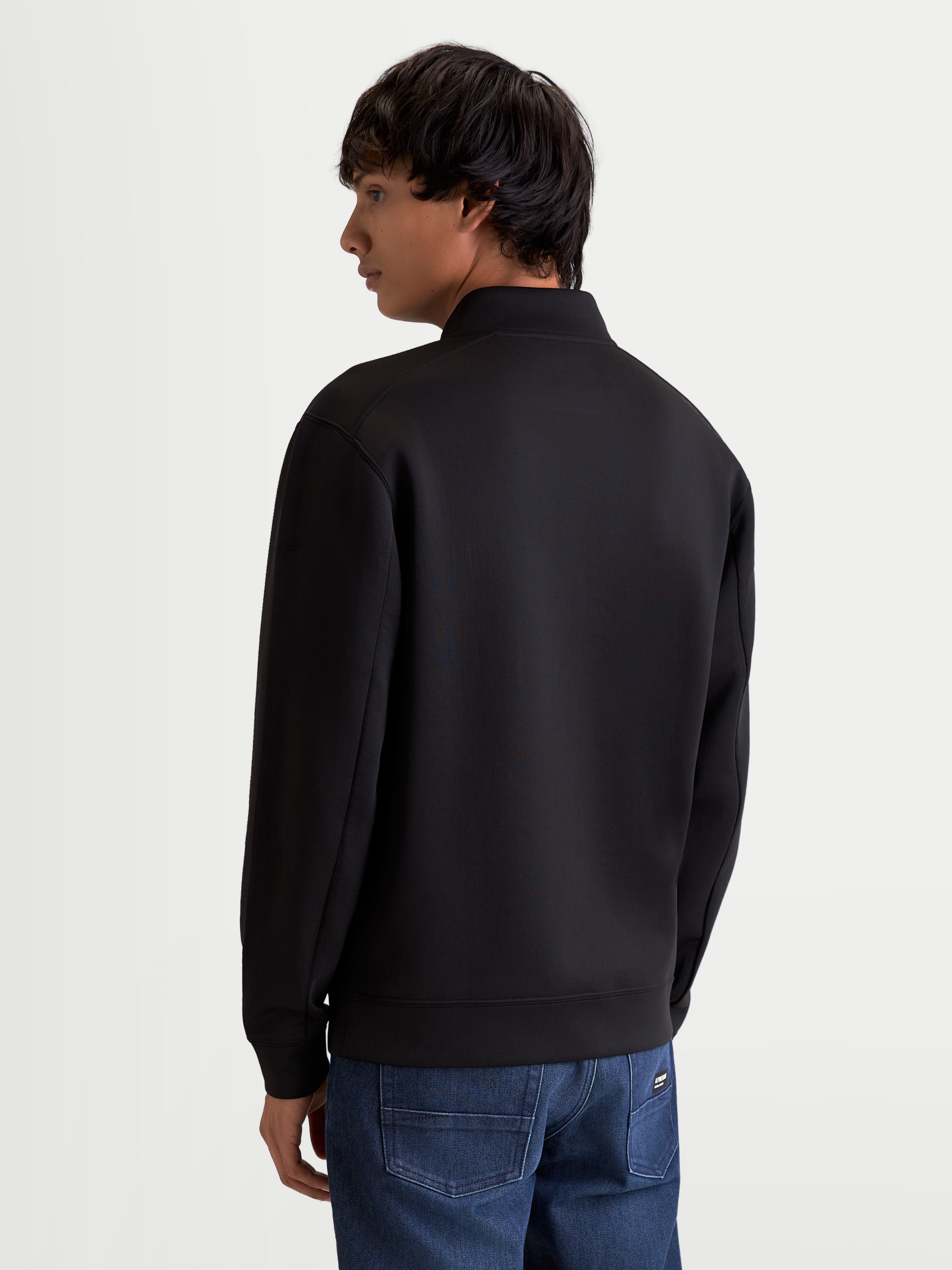 Alpinestars Bluza Apera Half-Zip, męska bluza sportowa, czarna, wykonana z polaru tri-blend, widok z tyłu na modelu pokazujący dopracowane szwy rękawów i krój lifestyle, odzież inspirowana motorsportem