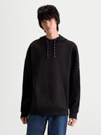 Alpinestars Camino Textured Oversized Hoodie, czarna bluza z kapturem unisex, styl lifestyle, teksturowany polar dzianinowy o splocie twill, wysoki kołnierz, kieszeń kangurka i haftowane logo na piersi, prezentowana na modelu.