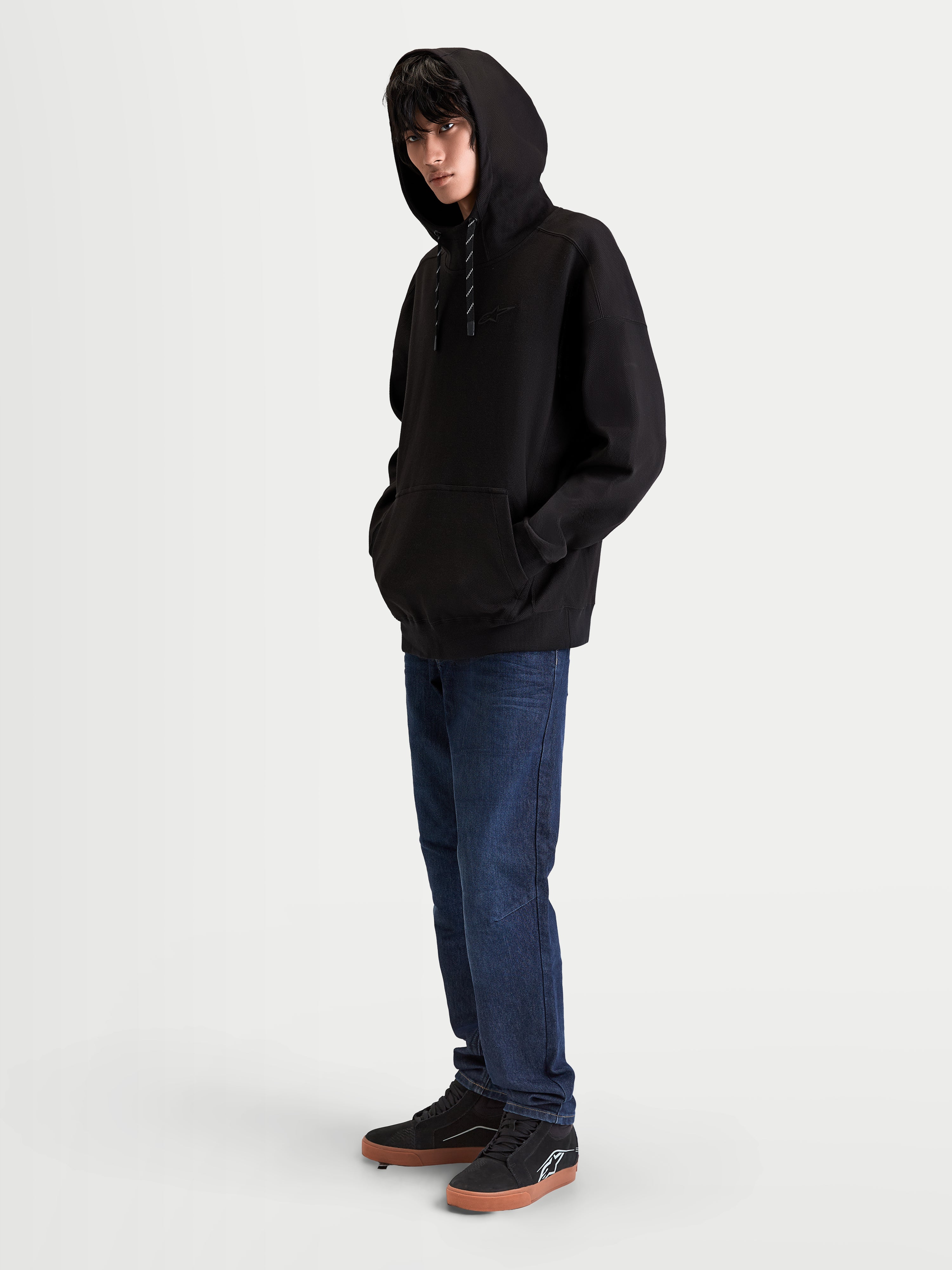 Alpinestars bluza z kapturem Camino Textured Oversized, czarna dresowa bluza typu pullover, krój oversize, teksturowany polar o splocie twill z wysokim kołnierzem i kieszenią typu kangurka, lifestyle'owa odzież sportowa w stylu motorsport.