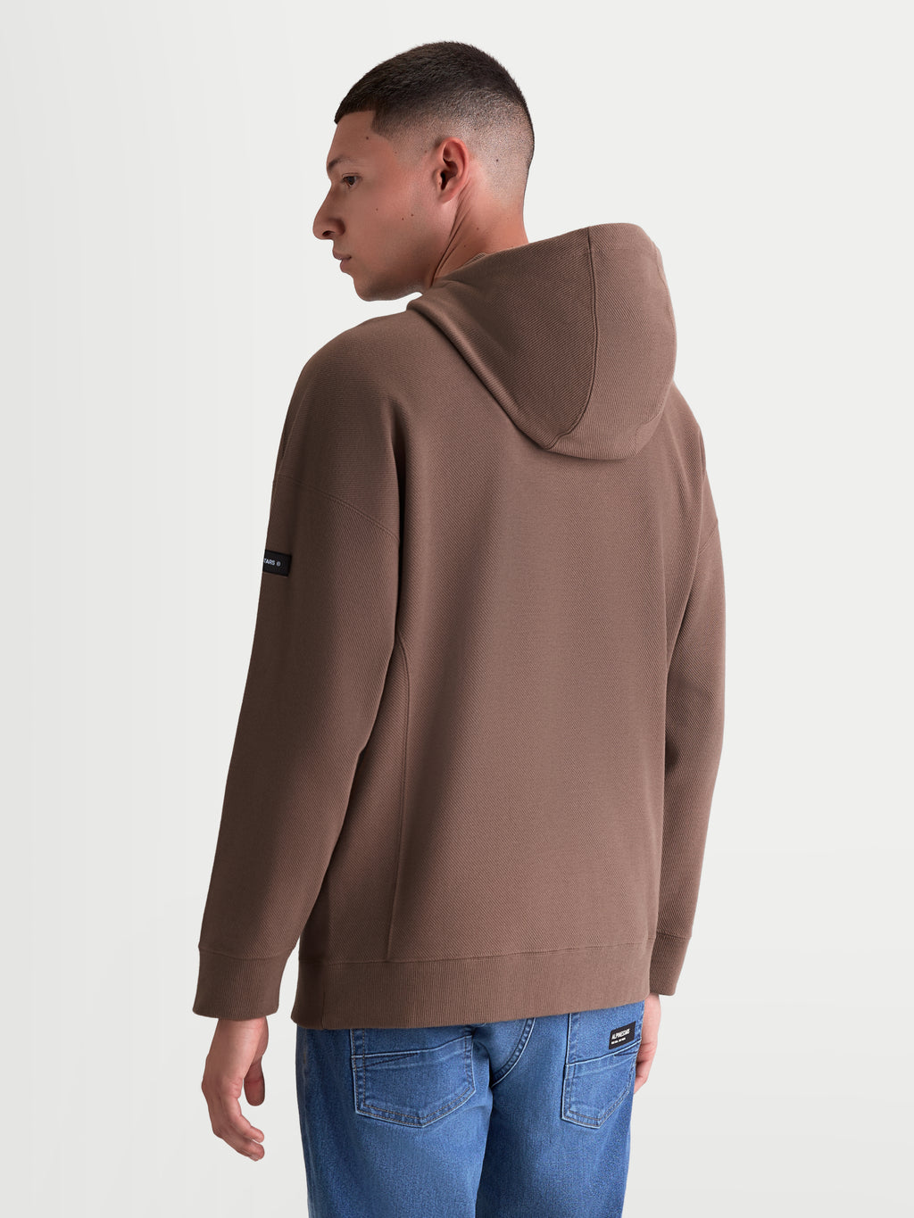 Alpinestars Bluza Z Kapturem Camino Textured Oversize, męska bluza sportowa, brązowa, wykonana z teksturowanego polaru o splocie twill, widok z tyłu prezentujący luźny krój i branding na rękawie.