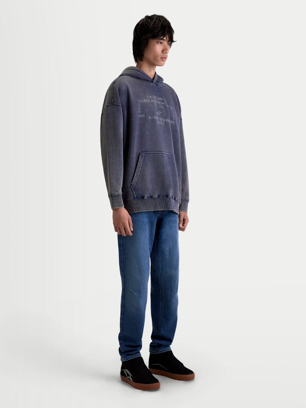 Alpinestars Infinite Washed Oversized Hoodie, sportowa bluza z kapturem, unisex, granatowa, polar z efektem snow-wash, luźny krój oversize, kieszeń kangurka i haftowane logo Alpinestars, zdjęcie na modelu w studio