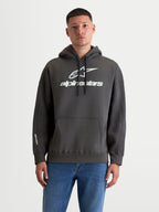 Alpinestars Prelude Oversize, męska bluza z kapturem, ciemnoszara i biała, prezentowana na modelu, luźny krój z kieszenią kangurka, białe wypukłe logo na piersi i rękawie, polarowa odzież sportowa z bawełny i poliestru z recyklingu.