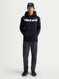 Alpinestars bluza z kapturem Velocifier, męska czarna bluza typu pull-over, biały logotyp Astars na piersi i logo na ramionach, premium mieszanka bawełny, casualowa odzież sportowa, zaprezentowana na modelu z czarną czapką z daszkiem.