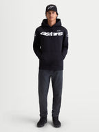 Alpinestars bluza z kapturem Velocifier, męska czarna bluza typu pull-over, biały logotyp Astars na piersi i logo na ramionach, premium mieszanka bawełny, casualowa odzież sportowa, zaprezentowana na modelu z czarną czapką z daszkiem.