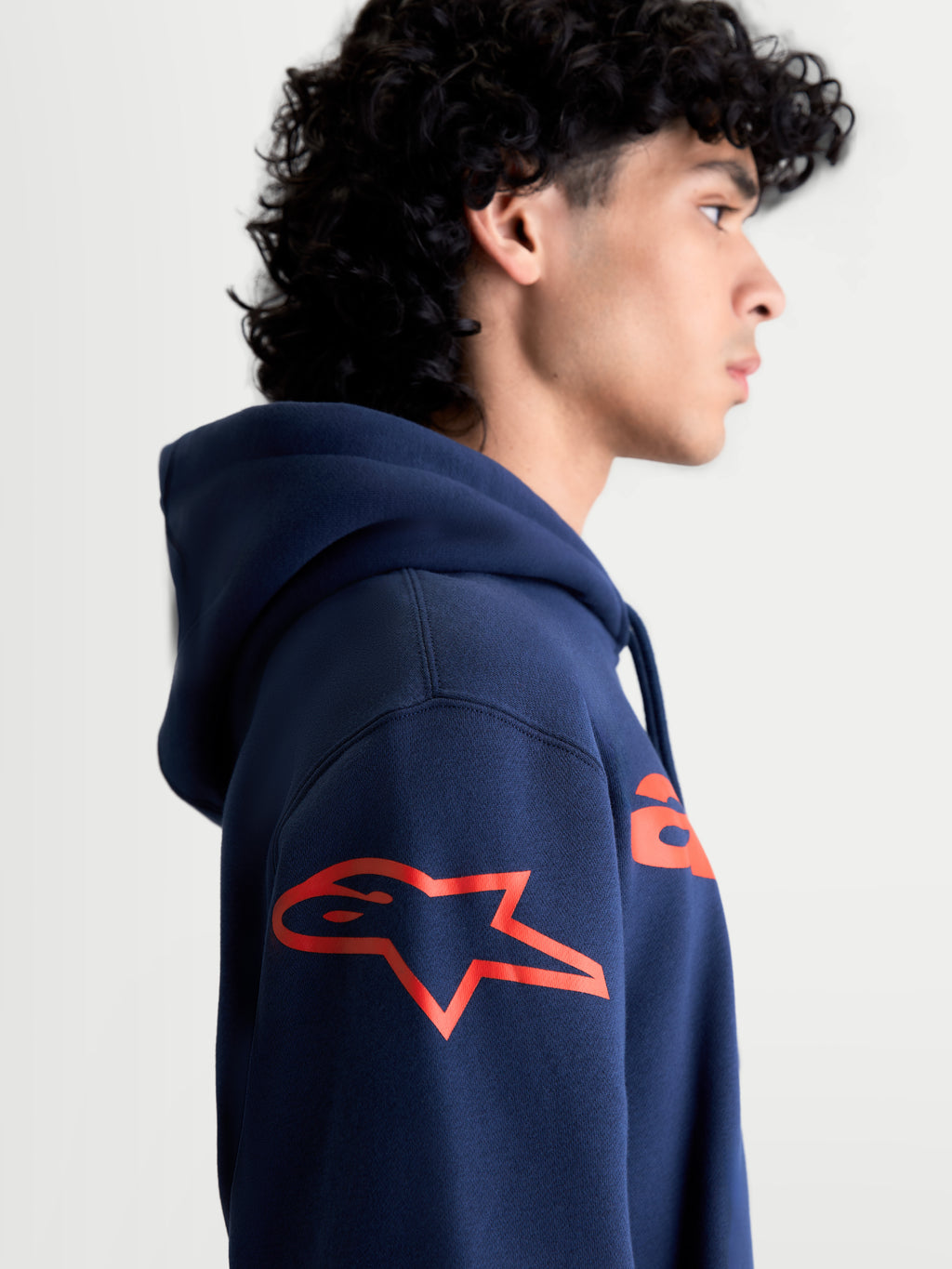 Alpinestars bluza z kapturem Velocifier, męska bluza sportowa typu pullover, granatowa i czerwona, widok z boku z czerwonym logo Astars na ramieniu, komfortowy polar dla entuzjastów motorsportu.