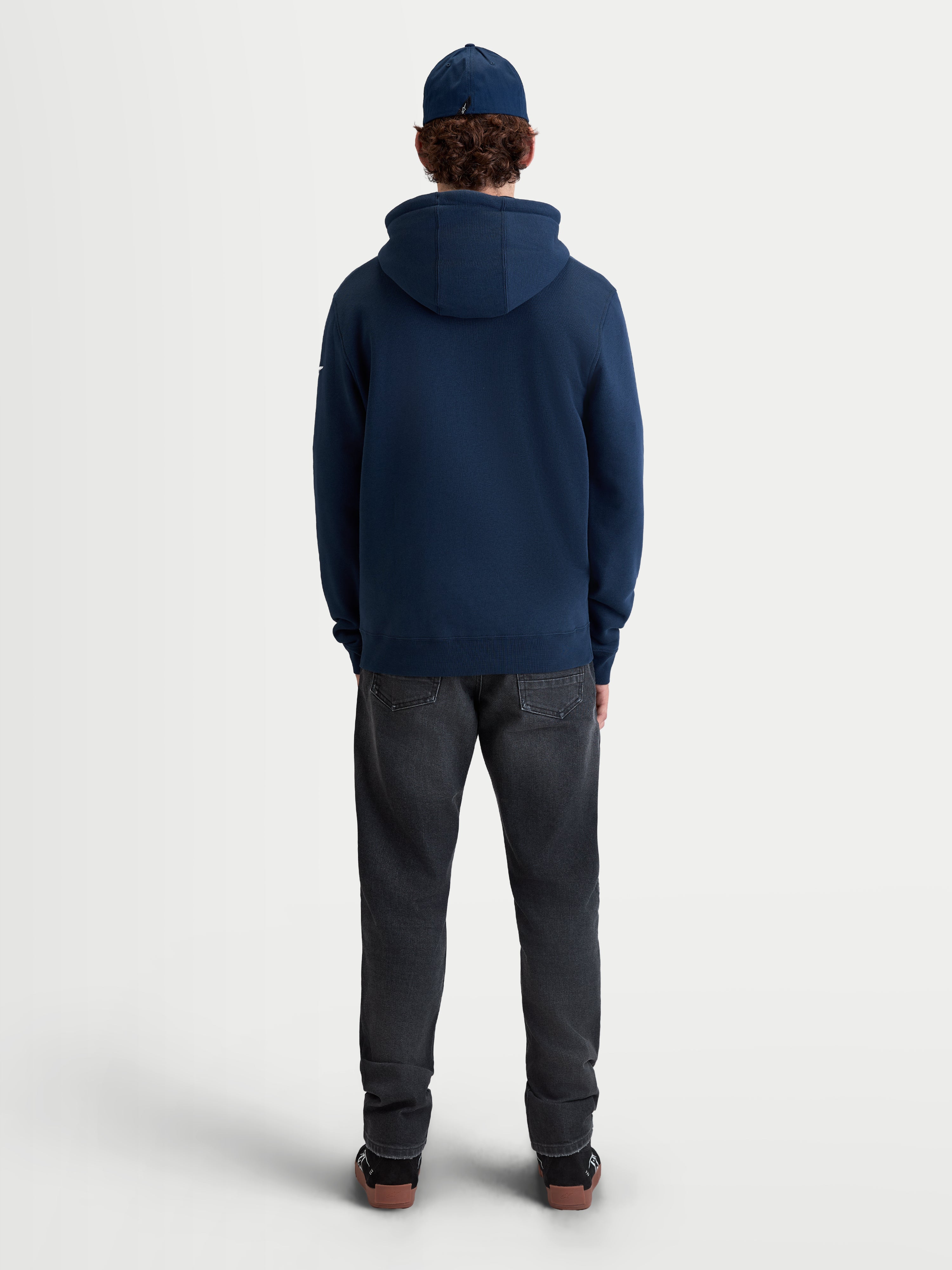 Alpinestars bluza z kapturem Race Wordmark, męska granatowa bluza z kapturem typu pullover, widok z tyłu na modelu, wykonana z polaru z mieszanki bawełny i poliestru z recyklingu, codzienna odzież sportowa w stylu motorsportowym