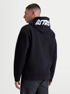 Alpinestars Pioneer Oversize, męska sportowa bluza z kapturem na zamek, czarna i biała, luźny krój oversize, biały haftowany napis ASTARS na kapturze, polar premium z przewagą bawełny, widok z tyłu na modelu.