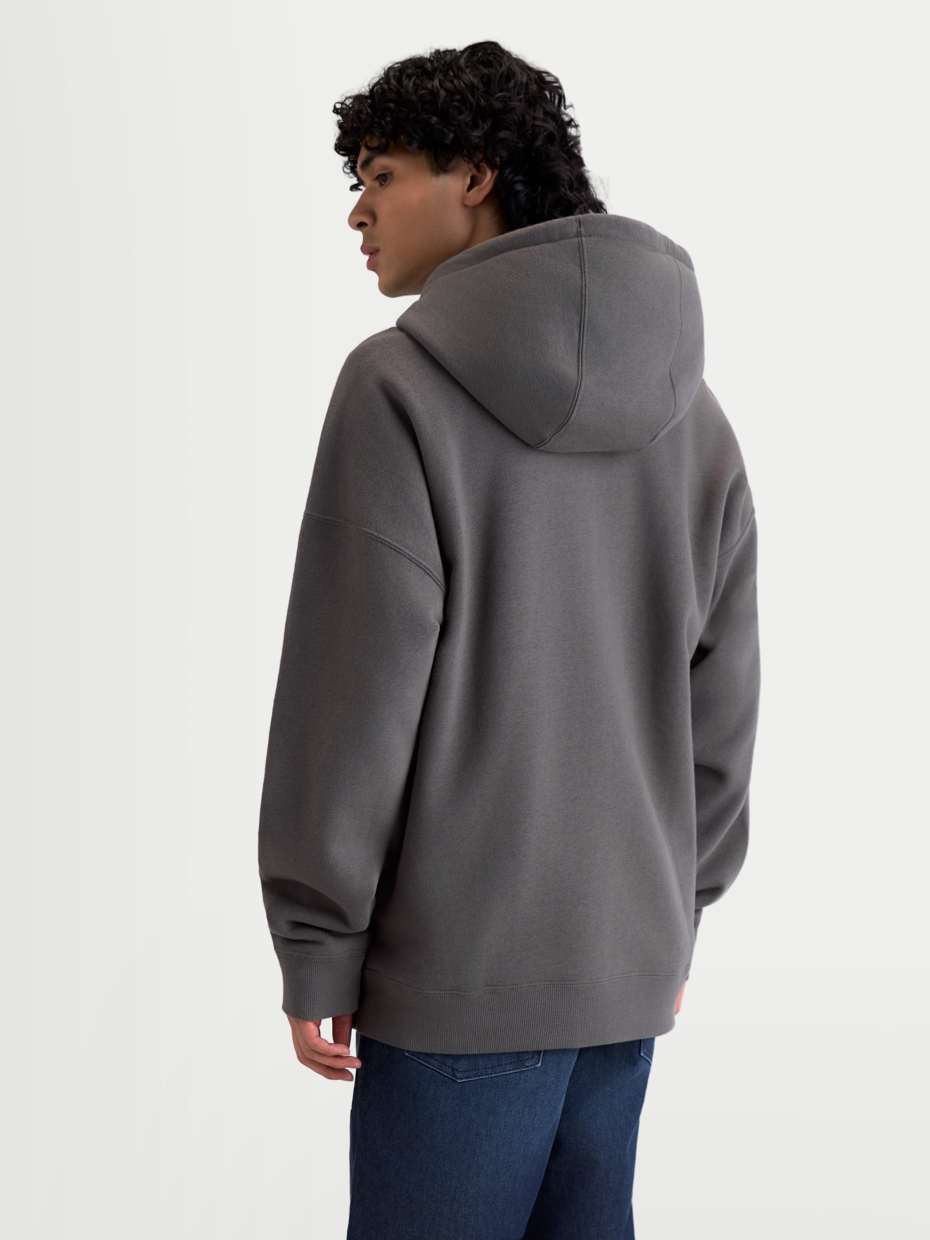 Alpinestars bluza z kapturem Entity Oversized, polarowa bluza sportswear na zamek, ciemnoszara, luźny fason typu oversize, widok z tyłu na modelu, prążkowany dół i mankiety.