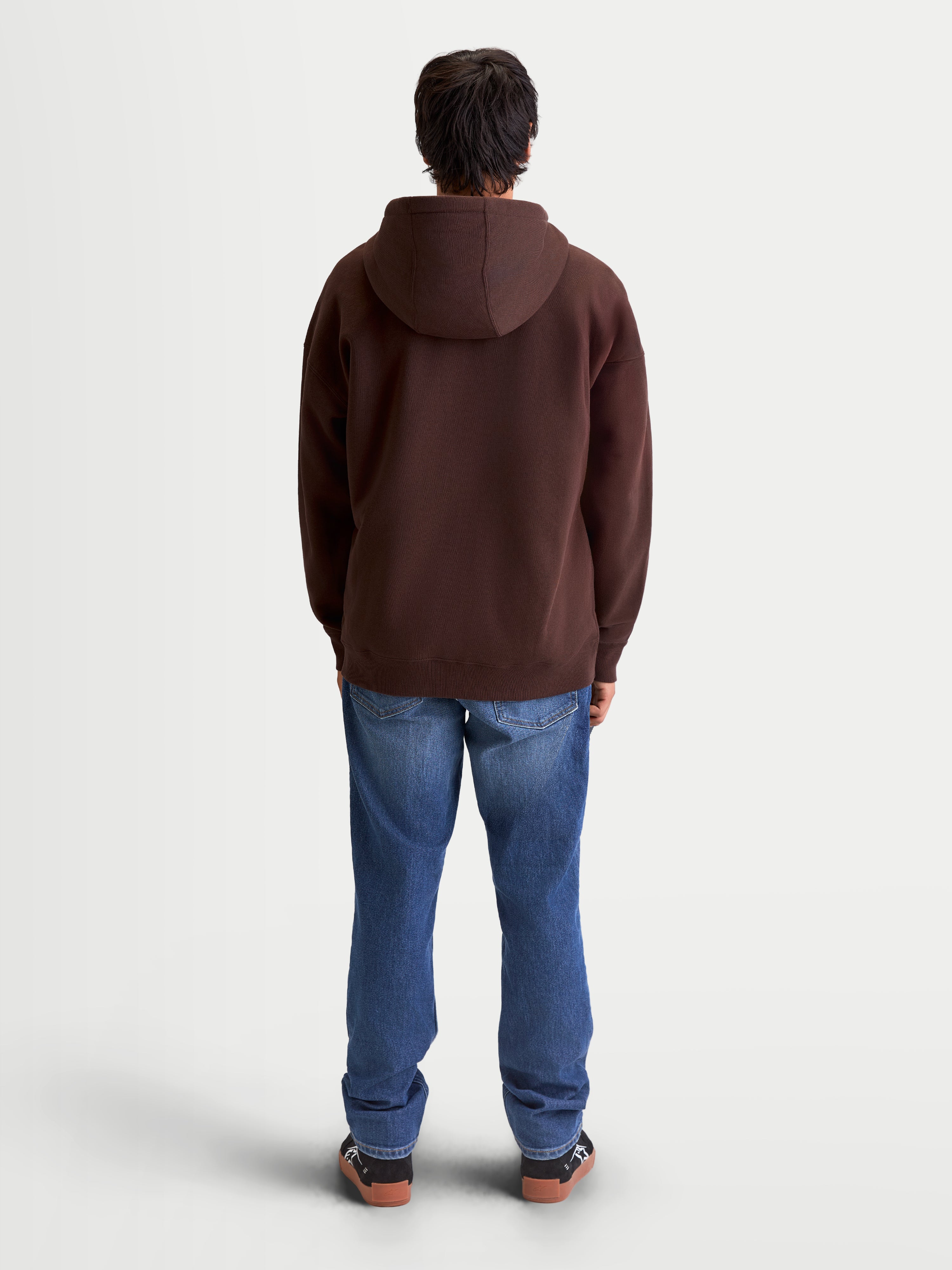 Alpinestars Bluza Z Kapturem Entity Oversized, brązowa sportowa bluza z kapturem widoczna z tyłu na modelu, luźny krój oversized, wykonana z polarowej mieszanki bawełny z recyklingu premium, casualowa odzież lifestyle.