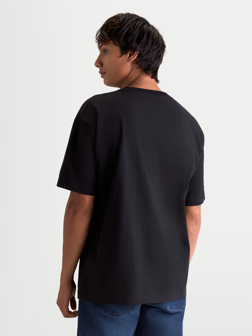 Alpinestars Chalk Oversized CSF Koszulka, czarna koszulka z krótkim rękawem, widok z tyłu na modelu, luźny krój oversize, casualowa odzież sportowa, wykonana z mieszanki bawełny i poliestru.