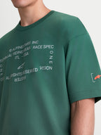 Alpinestars Koszulka Infinity Oversized CSF, zielona koszulka z krótkim rękawem typu oversize, biała grafika na klatce piersiowej oraz pomarańczowe logo Astars na rękawie, mieszanka bawełny i poliestru, casualowa odzież sportowa lifestyle.