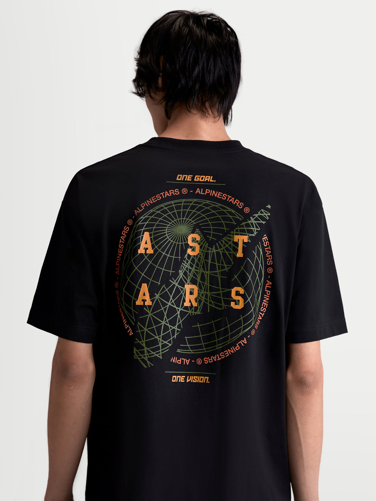 Alpinestars Latitude Oversized CSF Tee, czarna koszulka z krótkim rękawem, odzież sportowa, widok z tyłu na modelu, duża grafika z globusem, pomarańczowe logo ASTARS i hasło motorsportowe One Goal. One Vision.