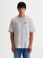 Alpinestars Mandate Oversized CSF, koszulka z krótkim rękawem, szara, czarne logo puff-print Astars na piersi, luźny krój oversize, model w casualowej odzieży sportowej.