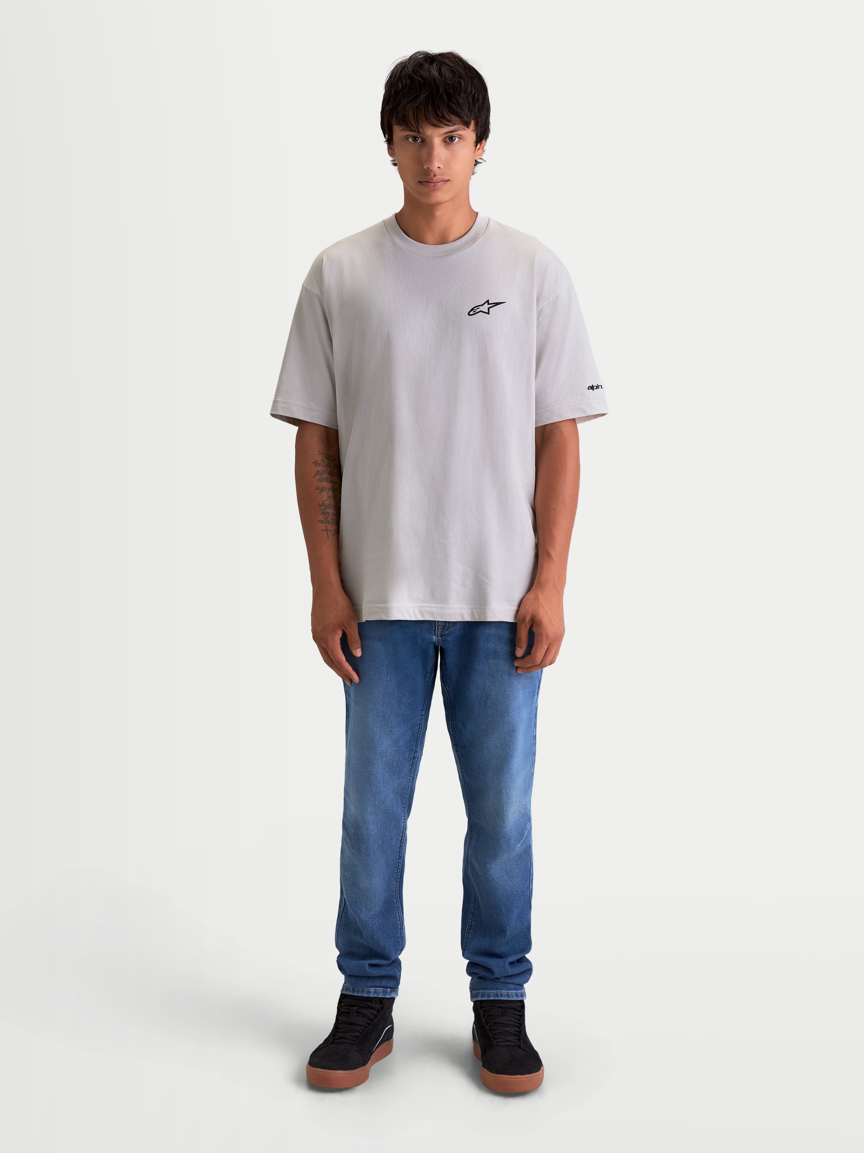 Koszulka Mandate Oversized CSF, męska koszulka sportowa z krótkim rękawem, szara, czarne wypukłe logo Astars na piersi, krój oversized, casualowa odzież lifestyle Alpinestars, grafika na rękawie, model prezentujący produkt.