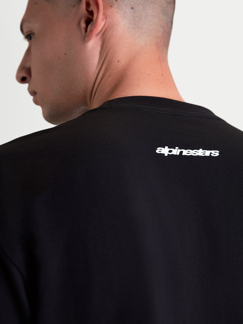Alpinestars Prelude Oversized CSF Tee, Black Short Sleeve Sportswear T-Shirt for Men and Women, features a white Alpinestars word logo graphic on the upper back, relaxed fit, soft cotton-poly blend for casual off-bike style.