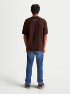 Alpinestars Prelude Oversized CSF Tee, Men's Short Sleeve Sportswear, Brown, Rear View on Model showing a small white Alpinestars word graphic on the back neck, oversized relaxed fit.