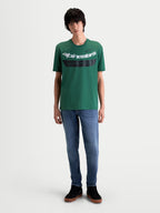 Alpinestars Koszulka Singular CSF, zielony t-shirt z krótkim rękawem, casualowa odzież sportowa w stylu motorsport, biała zakrzywiona grafika Astars oraz czarny detal na piersi z tekstem „One Goal. One Vision.”, widok na modelu od przodu, mieszanka bawełny i poliestru.