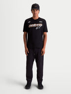 Alpinestars Koszulka Cypress CSF, męski t-shirt z krótkim rękawem, czarny, z grafiką Astars Word z siatkowym wypełnieniem i białym logo na piersi, model prezentujący casualową odzież sportową w stylu motorsport.